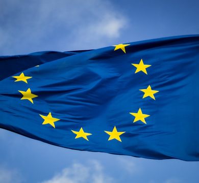 Die Flagge der Europäischen Union (dunkelblau mit gelben Sternen) weht im Wind. 