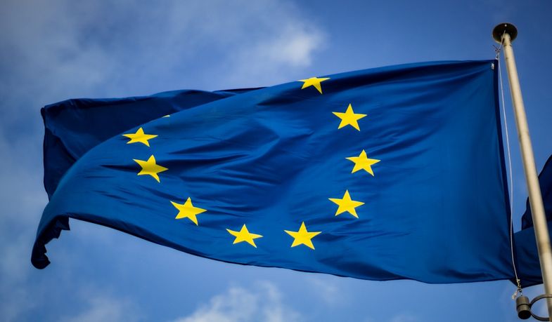 Die Flagge der Europäischen Union (dunkelblau mit gelben Sternen) weht im Wind. 
