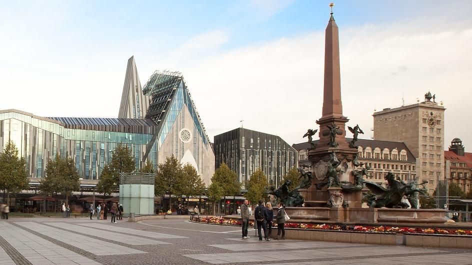 Blick auf den Campus am Augustusplatz. Das Gewandhaus ragt links heraus, dann erstreckt sich das Paulinum über das Bild. Der Mendebrunnen schließt das Bild rechts ab.